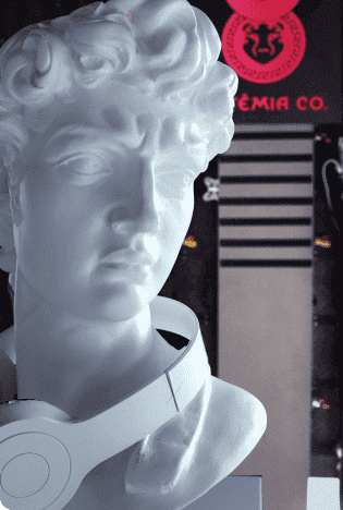agencia-de-marqueting-artemia estátua branca de deus grego com um fone no pescoço